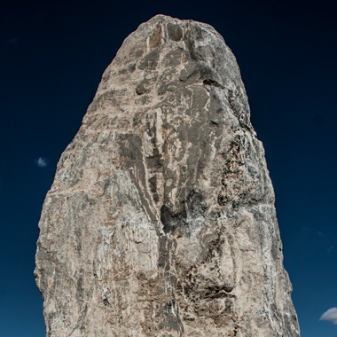 A large standing rock and deep blue sky